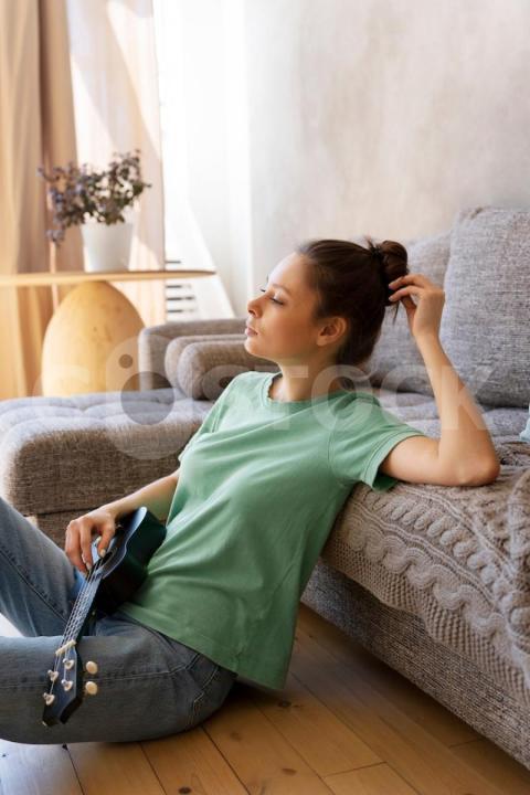 Young woman with messy bun playing ukulele 23 2149489003 jpg