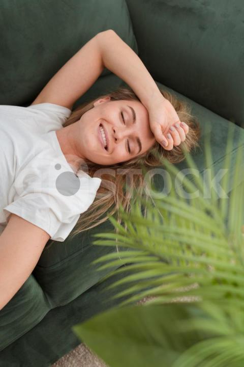 High view woman sitting couch smiling 23 2148537274 jpg